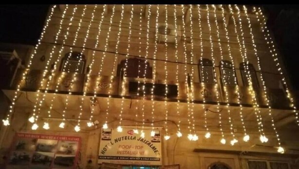 A building with a sign for "HOTEL NUTELLA JAISALMER" and a string of lights hanging above the entrance. - Hotel Nutella Jaisalmer By GRB (Jaisalmer)