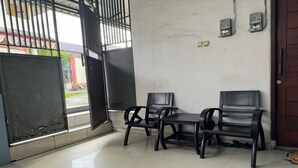 A room with a bench and chairs, a door, and a view of the outside. - Hotel O Widan Homestay (Samarinda)