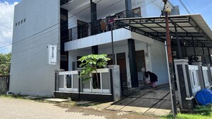 A two-story building with a balcony and a covered entrance. - Hotel O Widan Homestay (Samarinda)