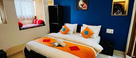 Un dormitorio con cama, ventana con cortinas, ventilador de techo e iluminación empotrada en la pared.