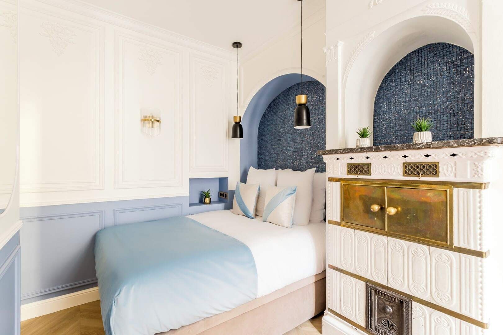 Un dormitorio con cama, cómoda, espejo y una pared azul decorativa.