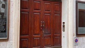 A large wooden double door with a metal handle and a glass panel above it. - Farini House - apartment in Modena (Modena)