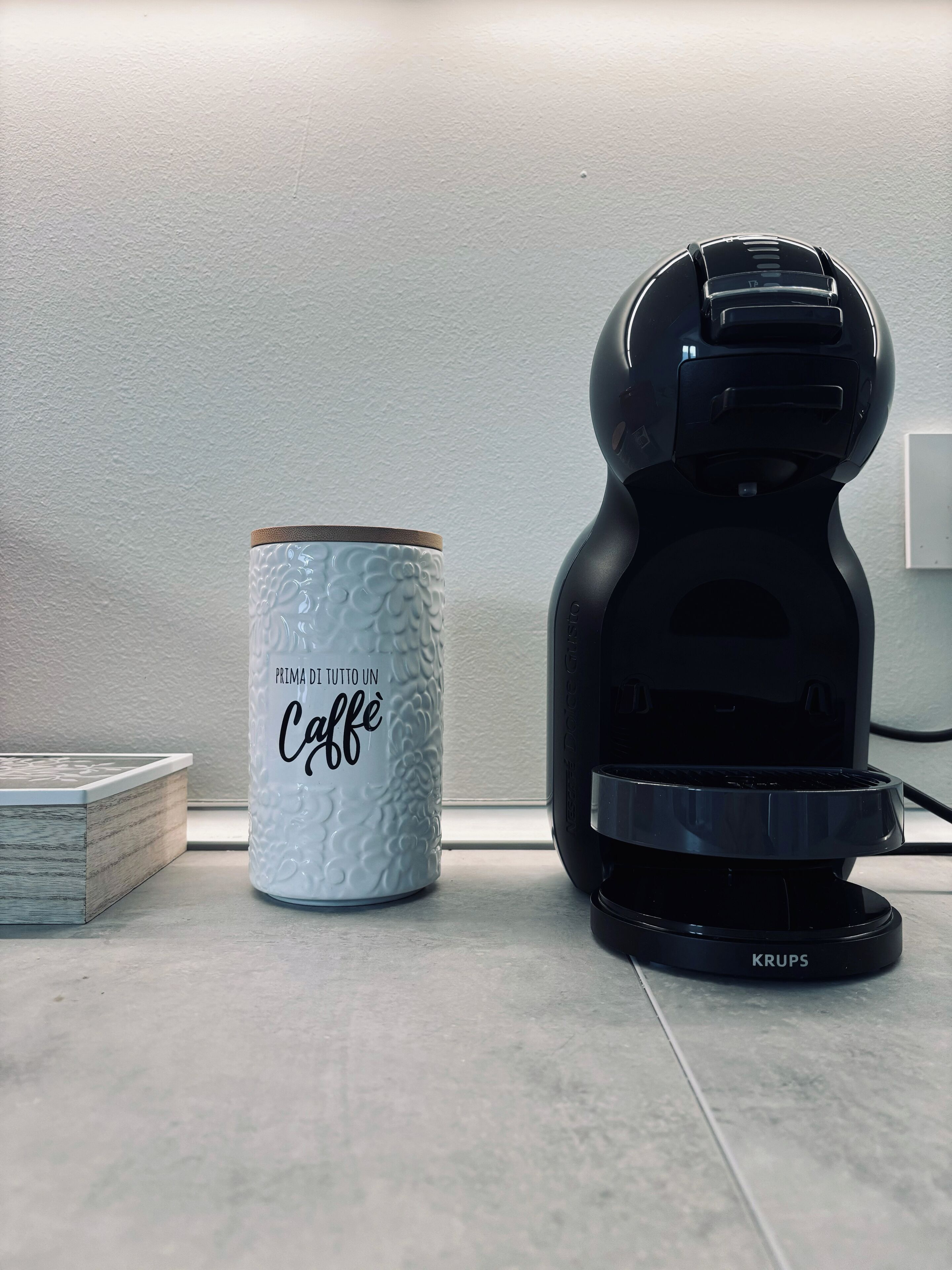 En kaffemaskine og en kop på en bordplade.
