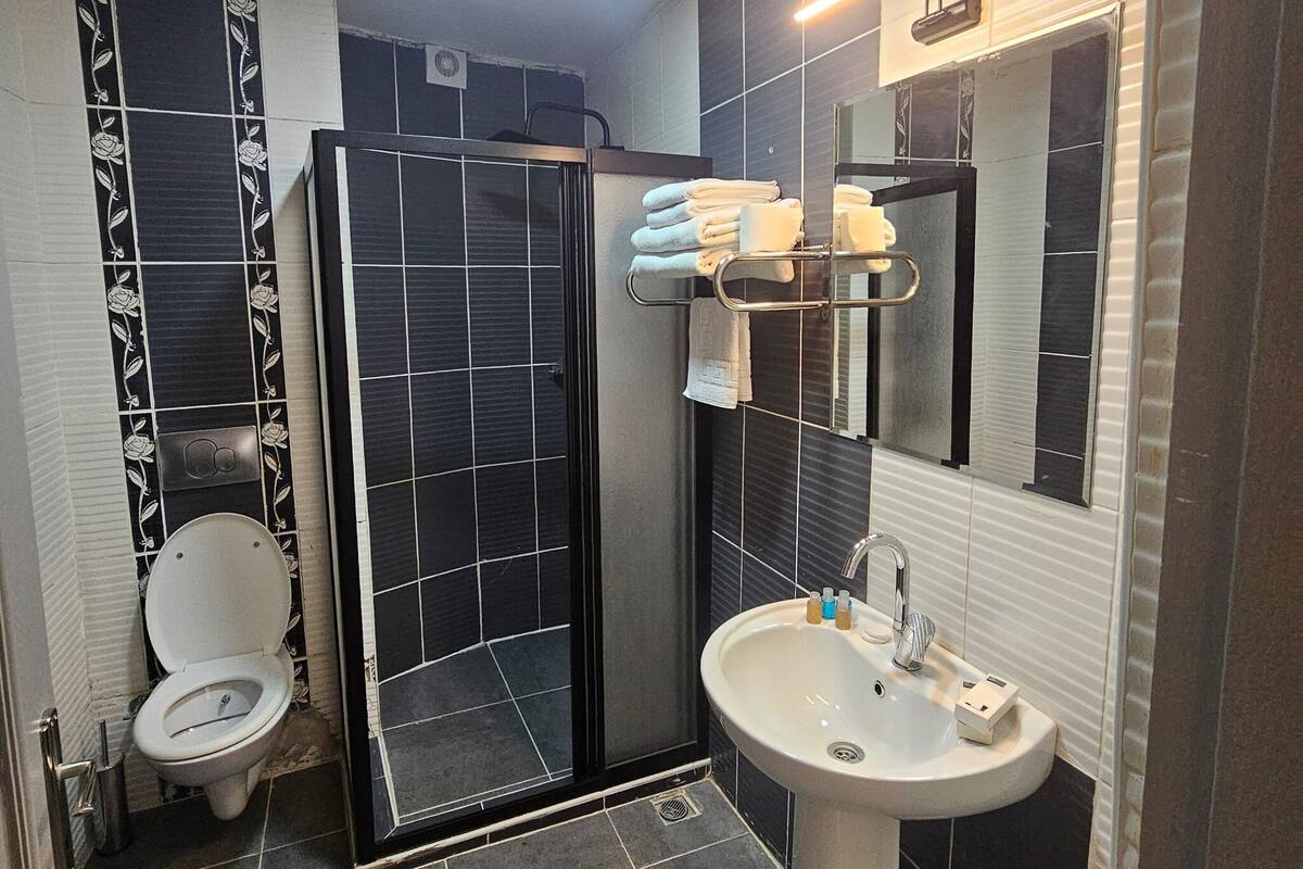 A modern bathroom with a toilet, sink, and shower.