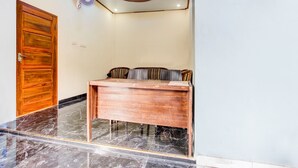 A reception desk with a wooden finish, a marble floor, a wooden door, and a ceiling fan.