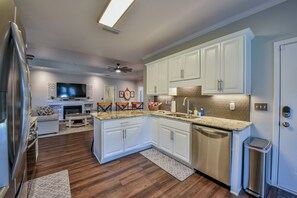 A modern kitchen with white cabinets, a stainless steel dishwasher, and a granite countertop. - Crimson Corner - Book for Football Season! (Tuscaloosa)