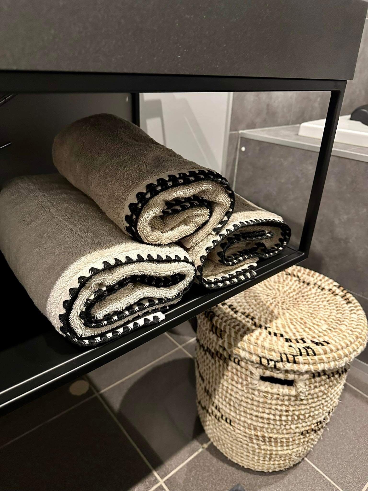 A shelf with rolled towels and a woven basket.
