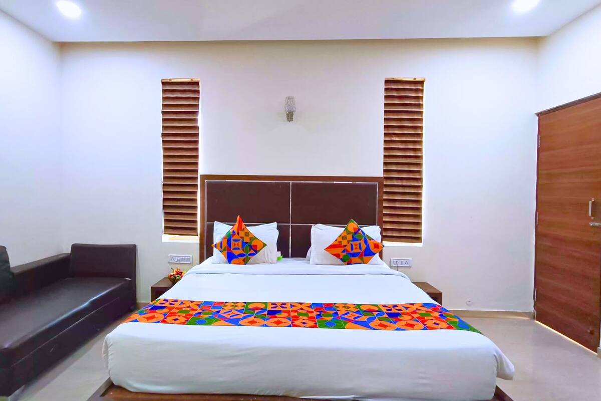 Une chambre à coucher comprenant un lit, une table de chevet, une commode et un canapé.