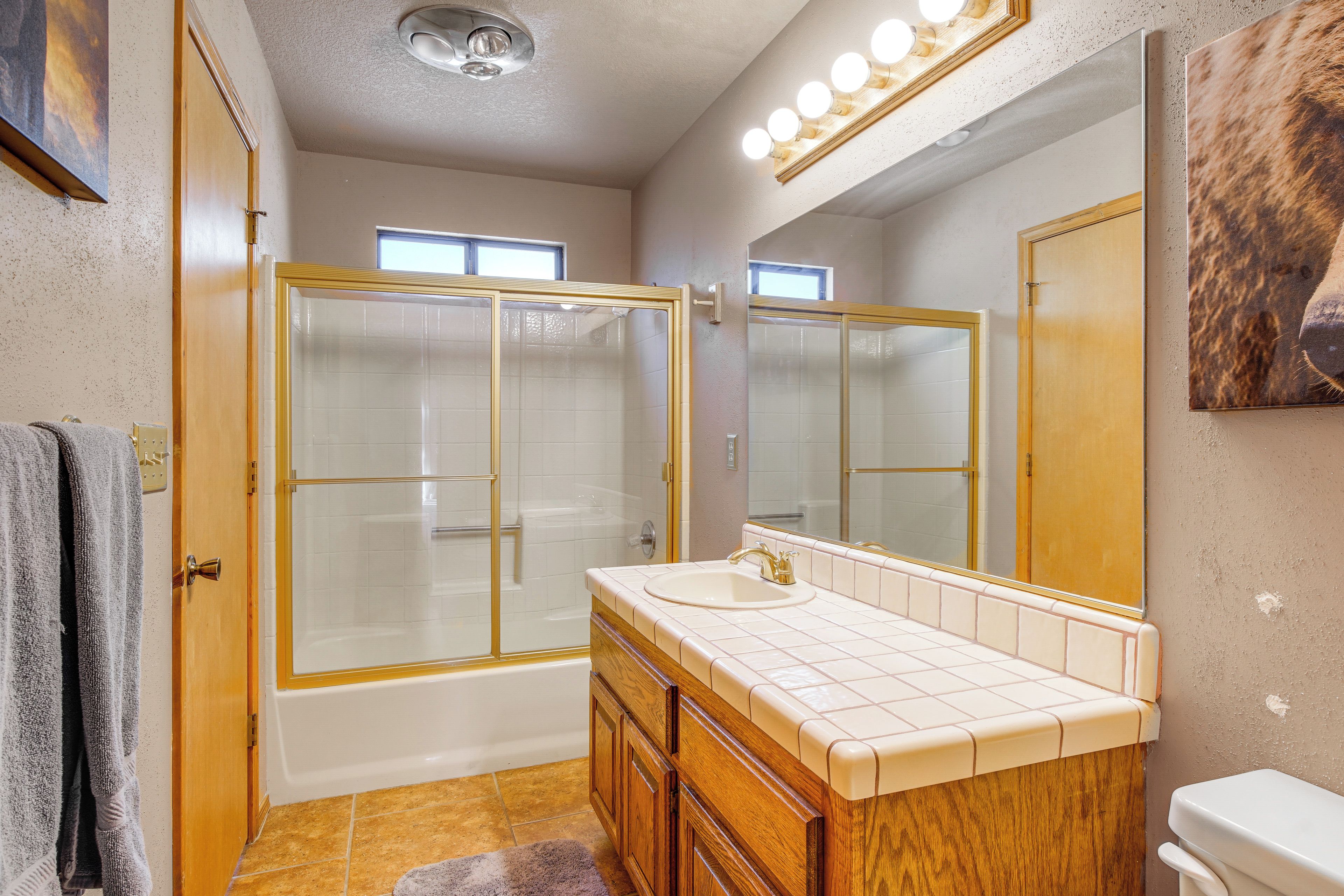 Une salle de bain avec une douche à parois de verre, un meuble-lavabo et un grand miroir.