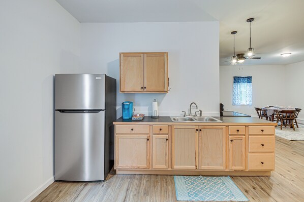 A modern kitchen with stainless steel appliances, wooden cabinets, and a dining area with a table and chairs. - Secluded Orland Cottage w/ Grill, Near State Parks (Orland)