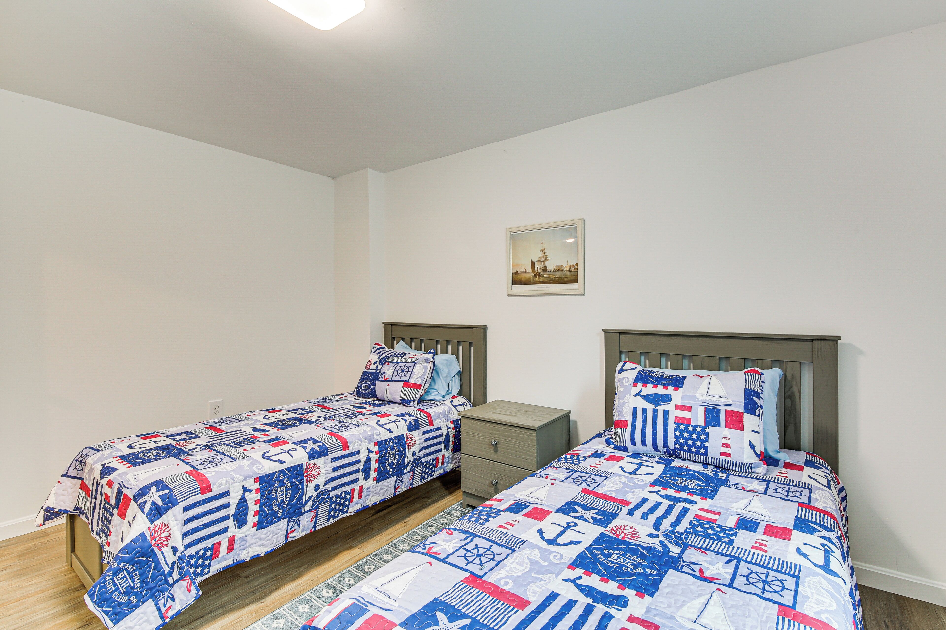 Ein Schlafzimmer mit zwei Einzelbetten, jeweils mit einem hölzernen Kopfstück und einem kleinen Nachttisch.