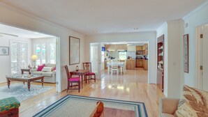 Un salón amplio con sofá, una mesa de centro y un comedor con sillas y una mesa.