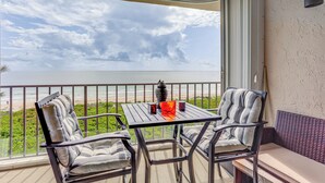 A balcony with a table and chairs, overlooking a beach and ocean. - Oceanfront Fort Pierce Condo: Pool & Beach Access! (Fort Pierce)