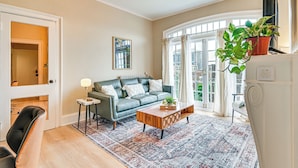Un salon avec un canapé, une table basse et un tapis à motifs.