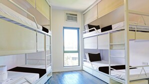 A room with bunk beds, a window, and a white air conditioning unit. - Spot On Hostel ,Taguig Manila Formerly MYTOWN HongKong (Taguig)