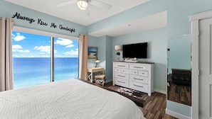 A bedroom with a large bed, a TV, a dresser, and a desk. - Origin 1203/1205 - Three Bedroom Connector Unit - Sunset Gulf View (Panama City Beach)