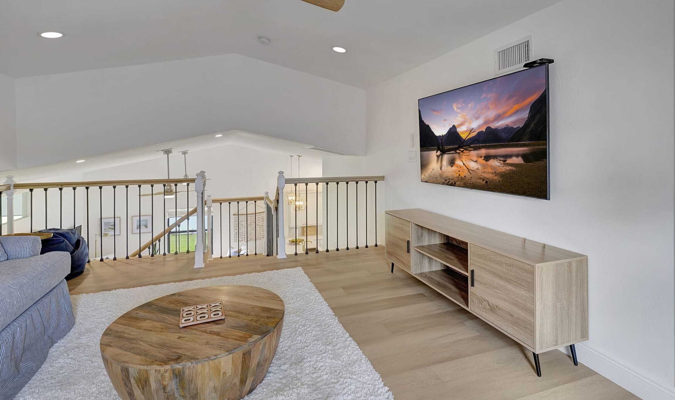 Un salon spacieux avec une table basse en bois, un canapé gris et un meuble TV en bois.