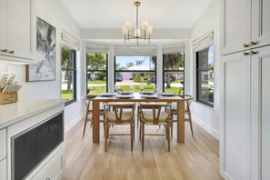 Una cocina moderna con comedor, ventanas amplias y vistas al exterior.