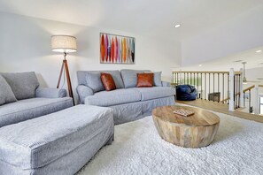 A modern living room with a sectional sofa, a round wooden coffee table, and a floor lamp.