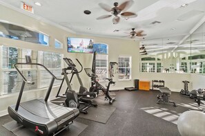 A gym with treadmills, stationary bikes, and free weights.