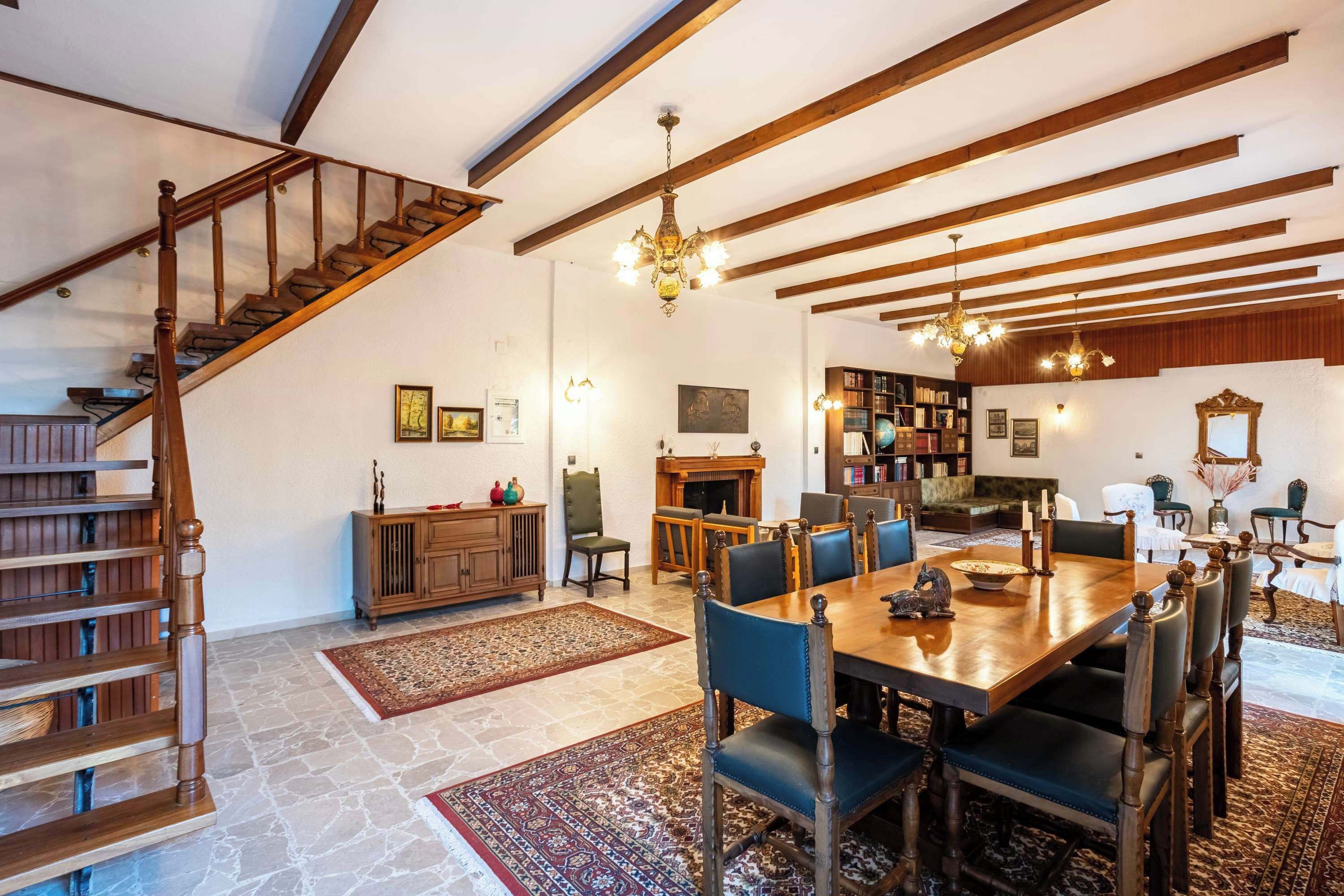 Spacious and cozy living area with rustic wooden beams and natural light, perfect for relaxing after a day at the beach or gathering with friends and family.
