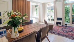 Un comedor moderno con una mesa de madera, sillas y un jarrón de flores.