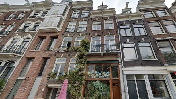 Una hilera de edificios de varios pisos con arquitectura europea tradicional, que destaca por sus elaborados marcos de ventanas y balcones.