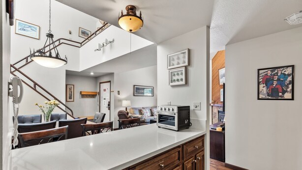A modern kitchen with a large island, wooden cabinets, and a built-in oven. - Cozy Mountain Retreat at Timber Run 101! (Steamboat Springs)