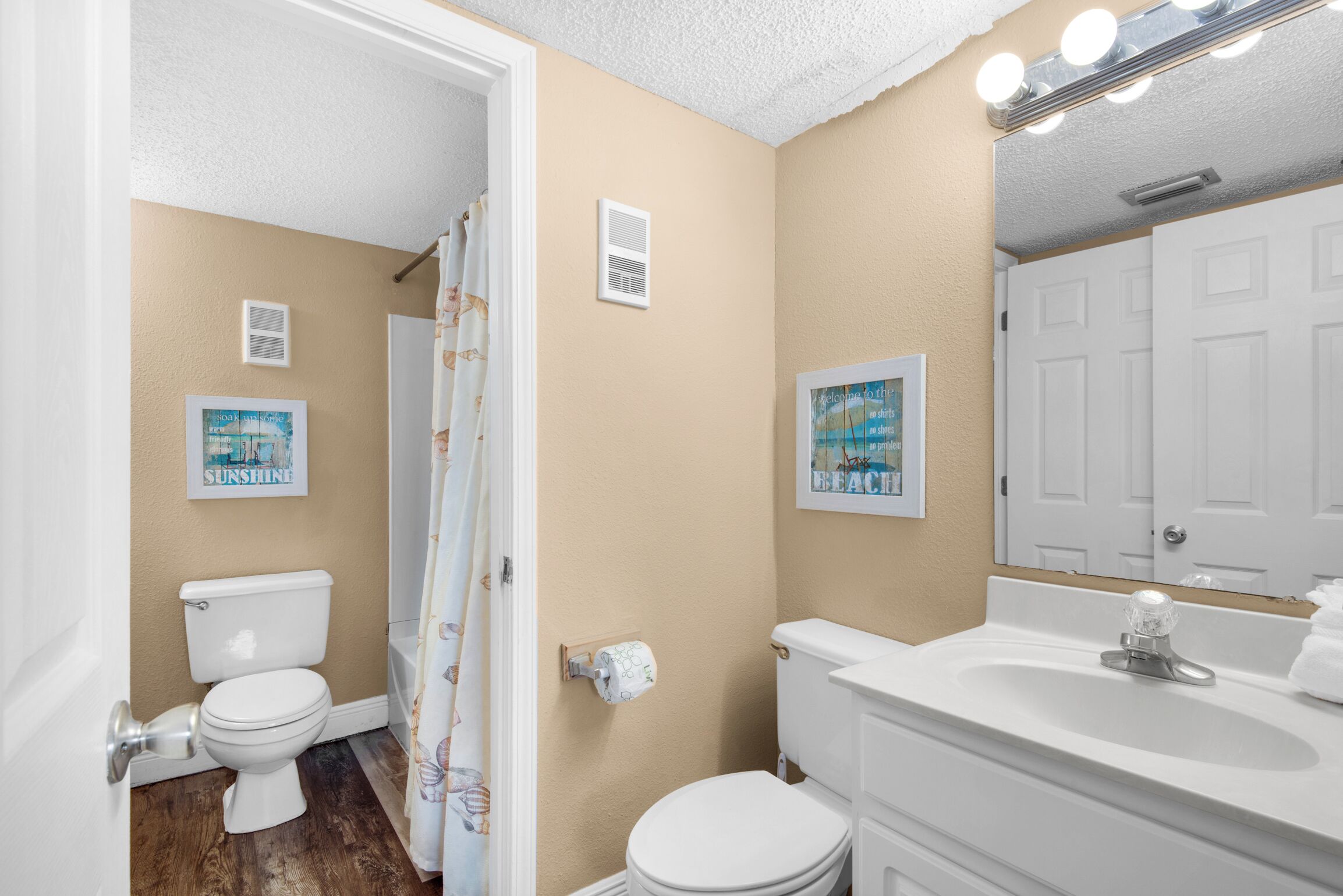 A bathroom with a toilet, sink, and shower curtain.