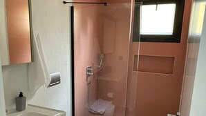 Une petite salle de bain comprenant des toilettes, une douche et un lavabo.