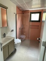 Un baño pequeño con inodoro, ducha y lavamanos.