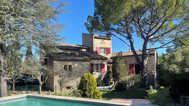 A stone building with a swimming pool, surrounded by trees and a fenced area. - Villa en plein coeur d'Uzès (Uzès)