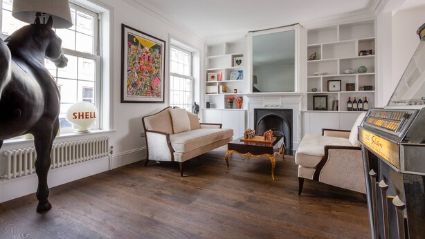 A living room with a fireplace, a sofa, a coffee table, and a piano. - Fulham Road X by Onefinestay (London)