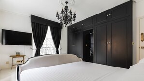 Un dormitorio con una cama grande, un televisor montado en la pared y un armario.