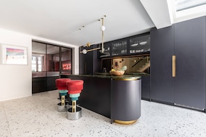 Enjoy cooking in this kitchen with sleek cabinetry, a central island, and a bar stool set.