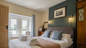 A bedroom with a bed, a window, a wardrobe, and a framed picture on the wall. - Gorgeous Rural 4 Bed Farm Cottage - With Hot Tub (Norton Saint Philip)