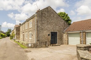 Un bâtiment en pierre avec une porte noire et un garage.