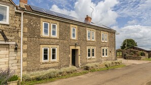 A stone house with multiple windows, a door, and a chimney. - Gorgeous Rural 4 Bed Farm Cottage - With Hot Tub (Norton Saint Philip)