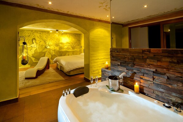A spa room with a large bathtub, a massage chair, and a massage table. - Luna Volcán, Adventure SPA - formerly Luna Runtún (Baños de Agua Santa)