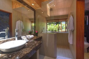 Un baño moderno con un lavamanos grande, espejo y ventana.