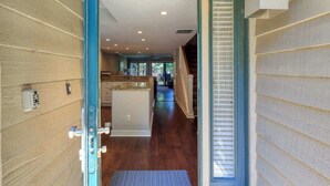 A hallway leading to a kitchen with wooden walls, a door with a handle, and a window with blinds. - Villa w/ Golf Views! Pool, Near Beach Hilton Head (Hilton Head Island)