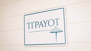 Un letrero con la palabra 'TI'PAYOT' y una ilustración de un paraguas.