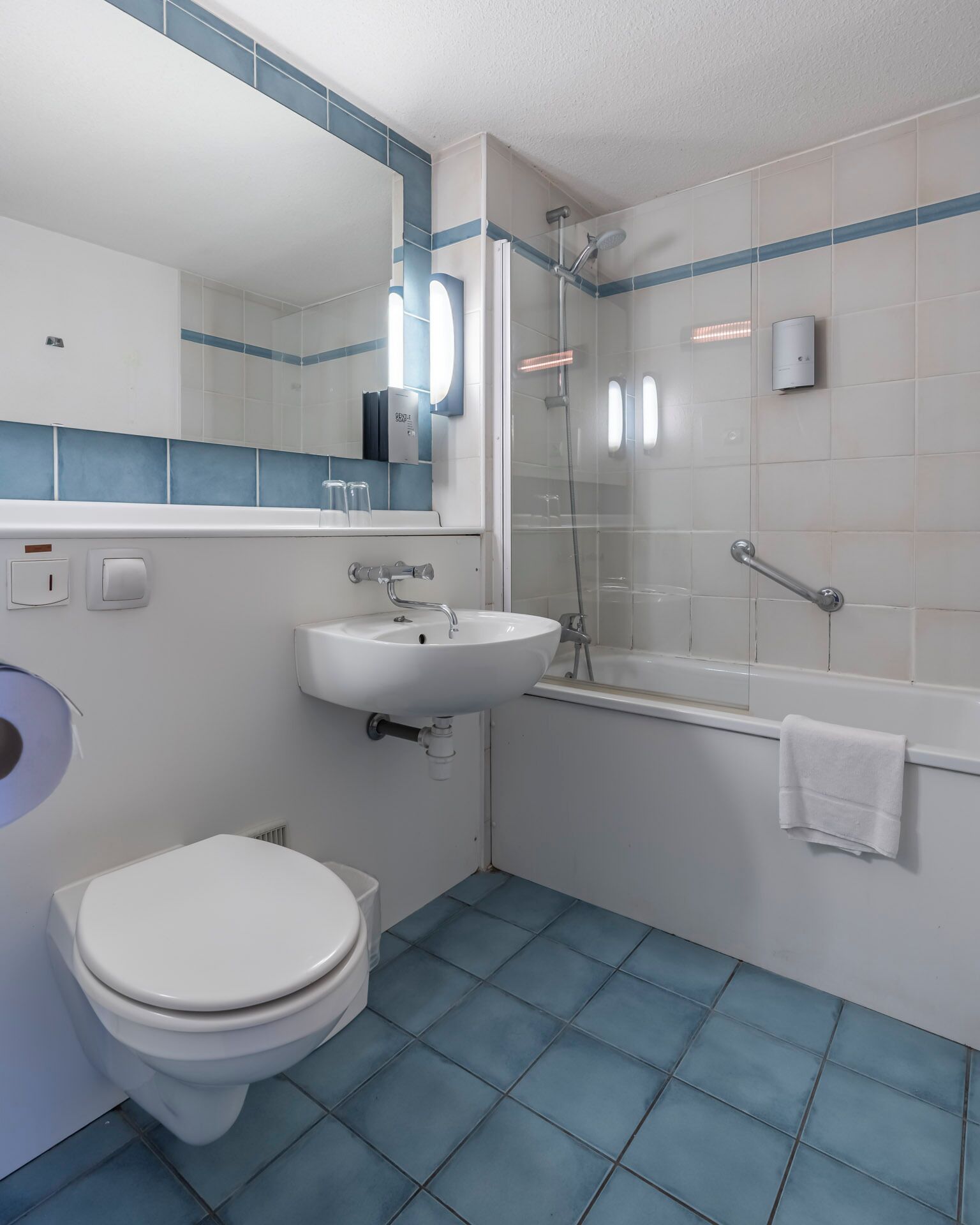 A bathroom with a toilet, sink, and shower.