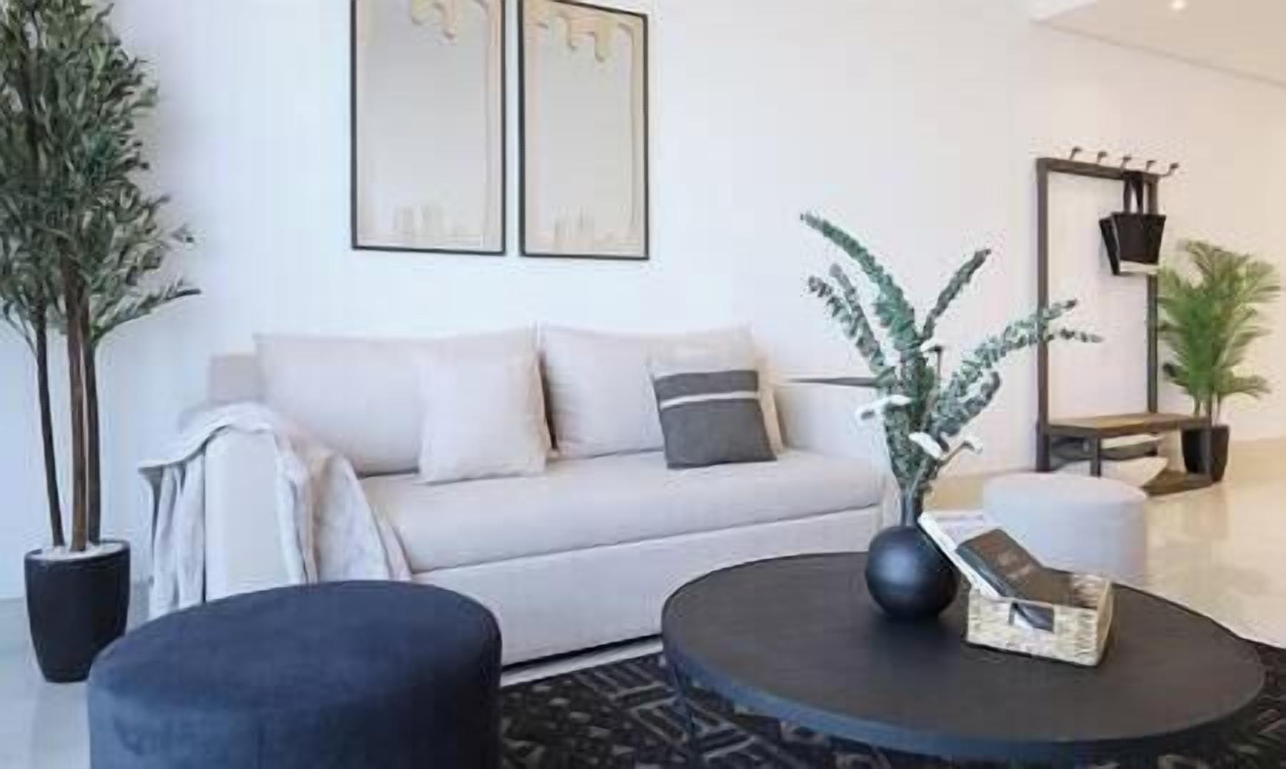 Un salon moderne avec un canapé, une table basse et des plantes décoratives.