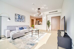A modern living room with a sofa, coffee table, and TV stand. - Bluewaters Oceanview Apt w/ Infinity Pool & Gym (Dubai)