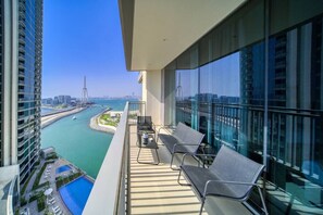 A balcony with a view of a marina and city skyline.