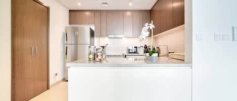 A modern kitchen with a central island, built-in appliances, and wooden cabinetry.