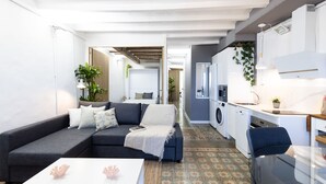 Un apartamento moderno con sala de estar, kitchenette y comedor.
