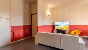 A room with a bed, a television, a fireplace, and a red and white color scheme. - Urban House - 301 in Monza (Monza)