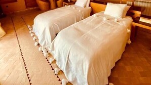 A bedroom with two beds, a wooden floor, and a traditional design. - Les dunes de Guemassa (Gmassa)